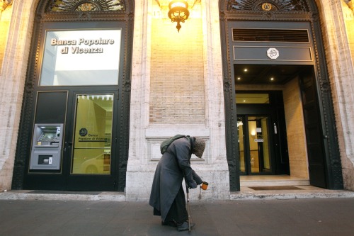 <YONHAP PHOTO-2160> A beggar walks past a bank in Rome, Thursday, Dec. 1, 2011. Italian Premier Mario Monti's financial rescue plan is yet to be finished, but that hasn't stopped unions from denouncing it and some politicians expressing doubts as to whether they can back the anticipated harsh measures to save Italy from bankruptcy. Monti told reporters Wednesday in Brussels that time constraints and the "extraordinary delicate situation" Italy is struggling through doesn't allow for "certain rituals that might be welcome by everyone, but perhaps aren't advantageous to the country." (AP Photo/Pier Paolo Cito)/2011-12-02 22:15:09/ <저작권자 ⓒ 1980-2011 ㈜연합뉴스. 무단 전재 재배포 금지.>
A beggar walks past a bank in Rome.  AP-Yonhap News