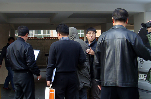 <YONHAP PHOTO-1787> 모친 살해 高3 현장검증 (서울=연합뉴스) 김동호 기자 = 좋은 성적을 강요하는 어머니를 살해하고 시신을 8개월 유기한 혐의로 구속된 A군에 대해 현장검증이 25일 오후 서울 구의동 자택에서 실시되고 있다. 회색 재킷으로 얼굴을 가리고 경찰관들에 둘러싸인 A군이 사건 현장으로 향하고 있다. 2011.11.25 dk@yna.co.kr/2011-11-25 22:30:59/ <저작권자 ⓒ 1980-2011 ㈜연합뉴스. 무단 전재 재배포 금지.>
A high school student arrested for murdering his mother re-enacts his crime at their home in Seoul on Nov. 25.   Yonhap News