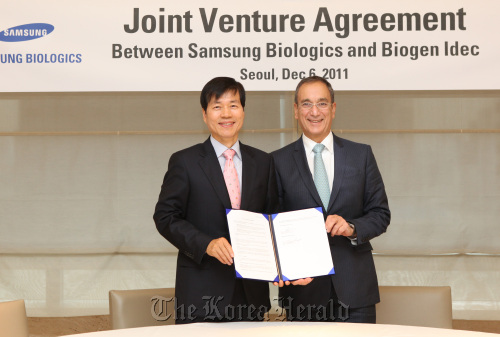 Samsung Biologics chief executive Kim Tae-han (left) and Biogen Idec CEO George Scangos pose for a photo after signing an agreement to set up a joint venture for biosimilars in southern Seoul on Tuesday. Samsung Biologics