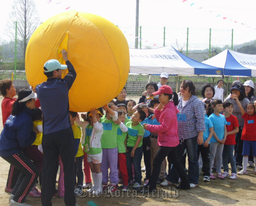Young defectors from North Korea have fun at sports day at Samjuk Elementary School in May, where they take regular classes while staying at Hanawon, the resettlement center for North Korean defectors, located near the school in Anseong, Gyeonggi Province.     Yonhap News
