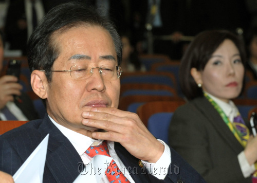 디도스 공격 후폭풍으로 지도부가 줄사퇴 하는 등 대홍란에 빠진 한나라당 홍준표 대표가 7일 오후 소집된 의원총회에서 고뇌하는 모습을 이두아(오른쪽) 원내대변인이 안타까운 표정으로 쳐다보고 있다.양동출dcyang@heraldm.com/111207/