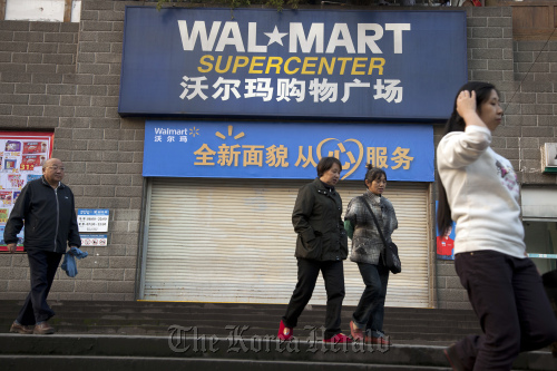 Pedestrians pass a shuttered Wal-Mart Stores Inc. outlet in Chongqing, China.  Bloomberg