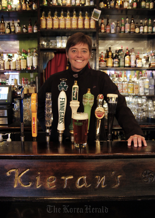 Jacquie Berglund stands behind the bar Nov. 22 at Kieran’s Irish Pub in downtown Minneapolis, which holds the record for selling the most Finnegans. Berglund is founder of the “spud society,” which sells Finnegans beer, giving 100 percent of the profits to charity.     Minneapolis Star Tribune/MCT