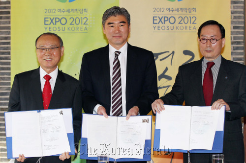 U.S. Ambassador Sung Kim (center) poses with Yeosu Expo organizing committee chief Kang Dong-suk (left) and Expo commissioner Lee Joon-hee after signing a U.S. participation contract for the expo in downtown Seoul on Monday.   Yonhap News