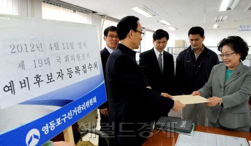 내년 4월 11일 실시되는 제 19대 국회의원 선거의 예비후보자 등록 첫날인 14일 민주당 이경숙 예비후보가 영등포 선관위에서 후보자 등록을 하고 있다.양동출dcyang@heraldm.com/111214/
Lee Gyeong-sook (right), chair of the Yeongdeungpo B constituency committee of the main opposition Democratic Party, submits her preliminary candidate registration papers for the April 11 general elections to the district election management committee in Seoul on Tuesday.     Yang Dong-chul/The Korea Herald