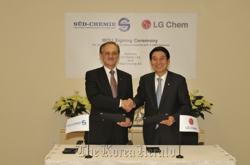 LG Chem’s chief executive and vice chairman Kim Bahn-suk (right) and Gunter von Au, chairman of German chemical firm Sud-Chemie Inc. pose for a photo after signing an agreement to establish a joint venture in Korea at a Sud-Chemie factory in Montreal on Tuesday.  LG Chem