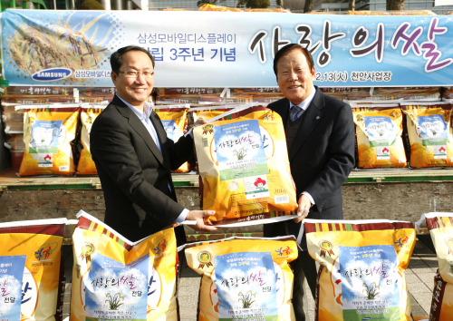 삼성모바일디스플레이가 13일 대형 트럭 31대 분량에 달하는 쌀 140t을 사업장 주변 도움이 필요한 이웃에게 전달하는 ‘쌀 나눔’ 행사를 가진 가운데 조수인(왼쪽) 사장이 충남 천안시청에서 성무용 천안시장에게 사랑의 쌀을 기증하고 있다.