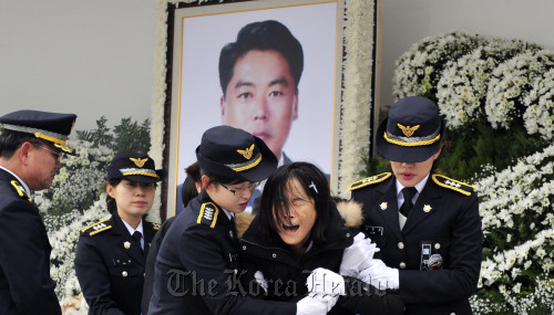 중국 어선의 불법어업을 단속하다 순직한 고 이청호 경사의 영결식이 14일 오전 인천 해경부두에서 열려 유가족들이 오열하고 있다.<br />인천= 김명섭 기자 msiron@
The members of the bereaved family cry during a funeral ceremony for Sergeant Lee Cheong-ho at a Korea Coast Guard pier in Incheon on Wednesday.   Kim Myung-sub/The Korea Herald