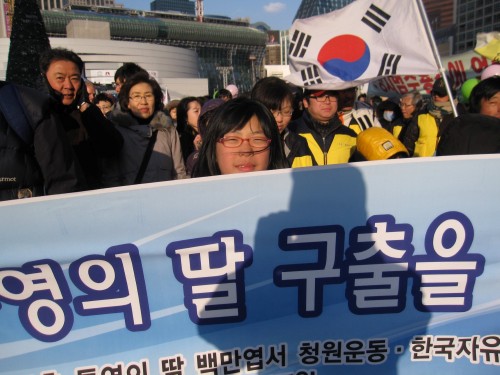 March organizer Choi Hong-jae’s daughter holds a banner at a rally for North Korean human rights near Seoul Plaza on Saturday.    (NKnet)