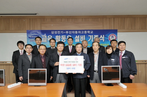 삼성전기는 지난 14일 산학협력 학교인 부산대와 부산자동차고(마이스터고)에 학생 실습용 설비를 각각 4대, 6대씩 기증했다. 이들 설비는 삼성전기 기판 제조공정에 사용되던 노광, 검사, 측정 설비들로 학생들의 실습에 사용된다. 김상기(앞줄 왼쪽) 삼성전기 전무(ACI경영지원팀장)가 이승희 부산자동차고 교장에게 설비 기증서를 전달하고 있다.