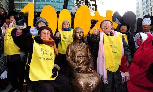 Former “comfort women” forced to provide sexual service to Japanese soldiers during and before World War II, hold their 1,000th weekly protest by the sculpture of a girl set up as a reminder of their history and a token of their wish for peace across from the Japanese Embassy in Seoul, Wednesday. They have rallied on Wednesdays for 1,000 weeks calling for the Japanese government’s apology and compensation. (Chung Hee-cho/The Korea Herald)