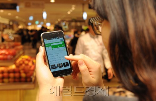 스마트폰 사용자.<br />이상섭 기자. babtong@heraldm.com 2011.12.18
A customer checks a message on her smartphone.   Lee Sang-sub/The Korea Herald