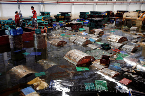 Aapico Hitech Pcl workers recover containers and raw steel rolls at the company’s flooded factory in the Hi Tech Industrial estate, Ayutthaya, Thailand.  Bloomberg
Aapico Hitech Pcl workers recover containers and raw steel rolls at the company’s flooded factory in the Hi Tech Industrial estate, Ayutthaya, Thailand.  Bloomberg