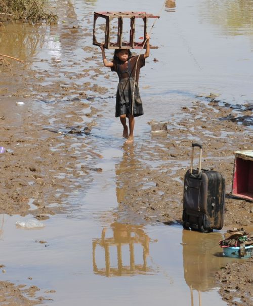 <YONHAP PHOTO-0700> A girl carrying a salvaged material walks through debris and flood waters along a street in Cagayan de Oro, in southern island of Mindnanao on December 18, 2011, a day after Typhoon Washi wrought havoc in the city. Philippine rescuers strived with mud, fatigue and the stench of death December 18 to help dazed survivors of devastating flash floods that have killed about 500 people. AFP PHOTO/TED ALJIBE /2011-12-18 15:06:49/ <저작권자 ⓒ 1980-2011 ㈜연합뉴스. 무단 전재 재배포 금지.>\r\n<YONHAP PHOTO-0700> A girl carrying a salvaged material walks through debris and flood waters along a street in Cagayan de Oro, in southern island of Mindnanao on December 18, 2011, a day after Typhoon Washi wrought havoc in the city. Philippine rescuers strived with mud, fatigue and the stench of death December 18 to help dazed survivors of devastating flash floods that have killed about 500 people. AFP PHOTO/TED ALJIBE /2011-12-18 15:06:49/ <저작권자 ⓒ 1980-2011 ㈜연합뉴스. 무단 전재 재배포 금지.>