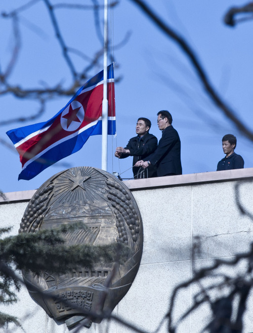 North Korean embassy staff members lower their national flag at half-mast to mourn the death of North Korean leader Kim Jong Il on the roof of the embassy in Beijing, China, Monday, Dec. 19, 2011. (AP)