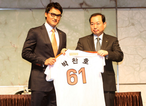 Hanwha Eagles CEO Jung Seung-jin (right) gives Park Chan-ho his jersey during the signing ceremony at the Plaza Hotel in Seoul on Tuesday.(Yonhap News)