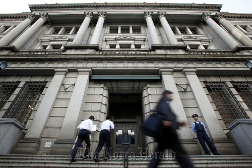 Pedestrians walk past the Bank of Japan headquarters in Tokyo.  Bloomberg
