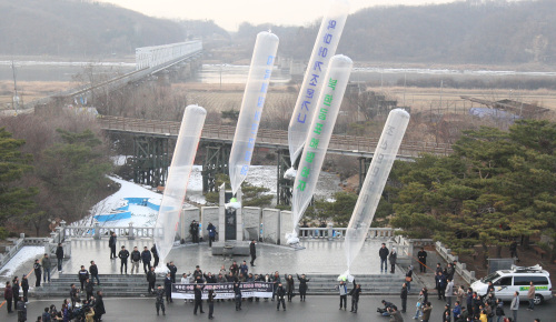 North Korean defectors launch balloons into the North in Paju, Gyeonggi Province, Wednesday carrying leaflets that criticize a power succession in the communist country. (Yonhap News)