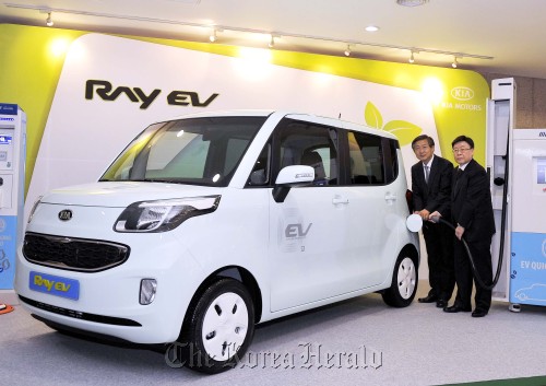 Yang Woong-chul (left), president of research and development at Hyundai-Kia and Chung Yun-kook, vice president for Kia’s domestic sales operation, charge the battery for an all-electric Ray at the company’s Namyang research center in Gyeonggi Province on Thursday.  Kia Motors
