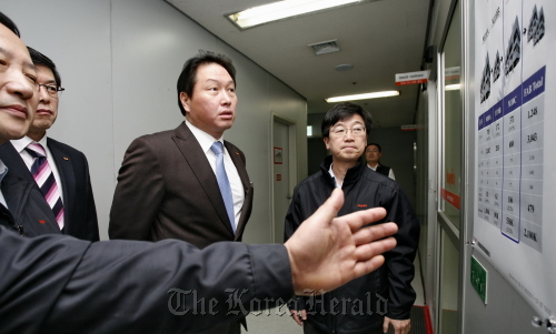 SK Group chairman Chey Tae-won is briefed by Hynix Semiconductor chief executive Kwon Oh-chul (left) during his visit to the Hynix headquarters in Icheon, Gyeonggi Province, on Thursday. SK