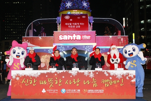 22일 신한금융그룹이 서울 청계광장에 만든 산타마을에서 한동우 신한금융 회장(오른쪽 두번째)과 박성중 사회복지공동모금회 사무총장(왼쪽 두번째)이 사랑의 크리스마스트리에 불을 밝히고 있다.  [사진제공=신한금융그룹]