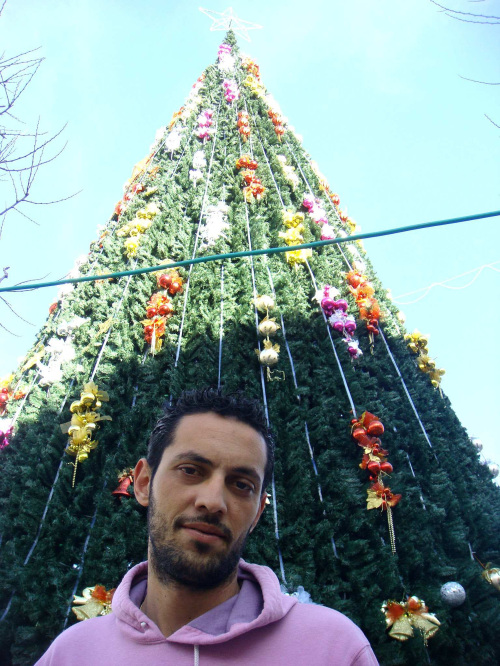 Nabil Giacaman, a third-generation wood carver,
stands near Bethlehem’s Manger Square, where
a 45-foot Christmas artificial tree was installed.
(Los Angeles Times/MCT)