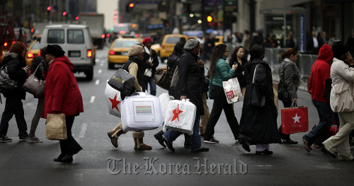 Shoppers cross the street in New York.  Bloomberg
