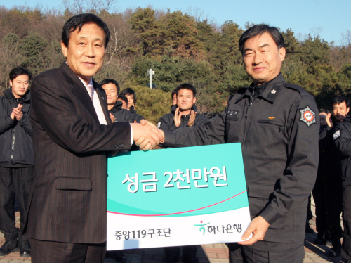 하나은행은 중앙119구조단에 기부금을 전달했다고 27일 밝혔다.  김정태(사진 왼쪽) 하나은행장이 지난 26일 경기도 남양주에 위치한 중앙119구조단에서 김준규 중앙119구조단장에게 기부금을 전달하고 있다.
