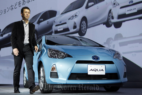 Satoshi Ogiso, executive general manager of Toyota Motor Corp., introduces the company’s Aqua hybrid vehicle during the launch in Tokyo on Monday.  Bloomberg