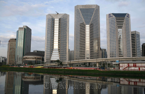 Buildings in the Bellini region are reflected in the Pinheiros River in Sao Paulo, Brazil.  Bloomberg