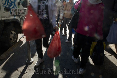 Pedestrians carry plastic shopping bags while walking through the Chinatown area in San Francisco, California.  Bloomberg