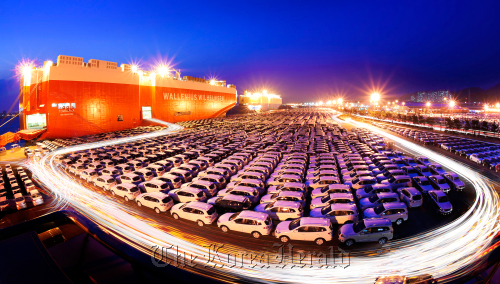Cars bound for export are loaded onto a transporter ship in Ulsan.     The Korea Herald