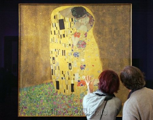 Visitors look at Gustav Klimt´s painting “Der Kuss” (The Kiss) in Vienna. AFP-Yonhap News