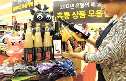 Customers take a look at makgeolli, wine and underwear with black dragon branding at a Lotte Mart in Seoul Station. (Yonhap News)