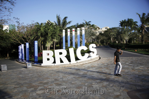 A man walks past a BRICS sign ahead of the summitt in Sanya, Hainan province, China.  Bloomberg
