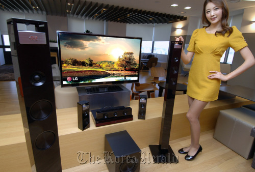 A model highlights LG Electronics’ three new 3-D home theater products, which will be launched in the North American region beginning in March, in Seoul on Tuesday. LG Electronics