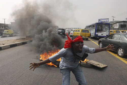 <YONHAP PHOTO-1666> An unidentified protester shouts slogans in front of a fire on a major road in commercial capital during a fuel subsidy protest in Lagos, Nigeria, Tuesday, Jan. 3, 2012. Angry mobs of protesters stopped gas station owners from selling fuel Tuesday while others lit a bonfire on a major highway in an attempt to thwart the government's removal of a cherished consumer subsidy that had kept gas affordable for more than two decades. (AP Photo/Sunday Alamba)/2012-01-03 23:30:17/ <저작권자 ⓒ 1980-2012 ㈜연합뉴스. 무단 전재 재배포 금지.>
A protester shouts in front of a fire on a major road during a fuel subsidy protest in Lagos, Nigeria on Tuesday. AP-Yonhap News