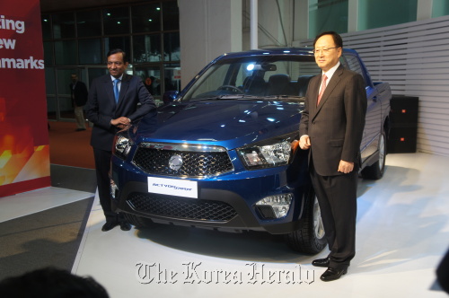 Ssangyong Motor CEO Lee Yoo-il (right) and Pawan Goenka, president of Mahindra & Mahindra, pose with Korando Sports at the New Delhi Auto Expo on Thursday. Ssangyong Motor