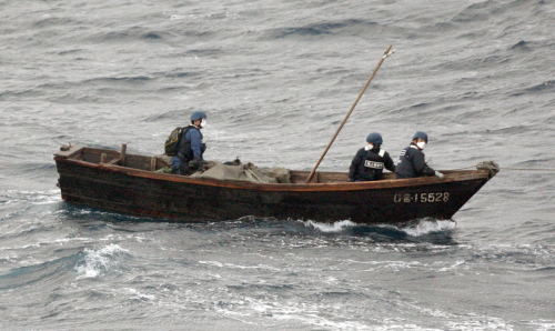 <YONHAP PHOTO-0615> A wooden boat, with the Japan Coast Guard officials on board, is towed by the coast guard's boat after it was found off Okinoshima, Shimane Prefecture, western Japan, Friday, Jan. 6, 2012. The small boat believed to be from North Korea has wandered into Japanese waters, carrying three men and a dead body. (AP Photo/Kyodo News) JAPAN OUT, MANDATORY CREDIT, FOR COMMERCIAL USE ONLY IN NORTH AMERICA/2012-01-07 19:06:59/ <저작권자 ⓒ 1980-2012 ㈜연합뉴스. 무단 전재 재배포 금지.>
A wooden boat with Japan Coast Guard officials on board is towed by the coast guard after it was found off Okinoshima, Shimane Prefecture, Friday.  AP-Yonhap News