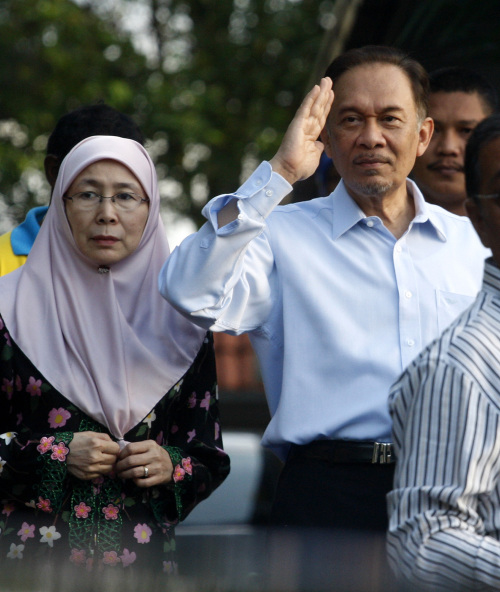 <YONHAP PHOTO-0362> Malaysian opposition leader Anwar Ibrahim, right, salutes beside his wife Wan Azizah as he prepares to leave his residence to the High Court for his sodomy trial verdict in Kuala Lumpur, Malaysia, Monday, Jan. 9, 2012. (AP Photo/Lai Seng Sin)/2012-01-09 10:21:40/ <저작권자 ⓒ 1980-2012 ㈜연합뉴스. 무단 전재 재배포 금지.>
Malaysian opposition leader Anwar Ibrahim (right) salutes beside his wife Wan Azizah in Kuala Lumpur on Monday. AP-Yonhap News
Malaysian opposition leader Anwar Ibrahim (right) salutes beside his wife Wan Azizah in Kuala Lumpur on Monday. AP-Yonhap News