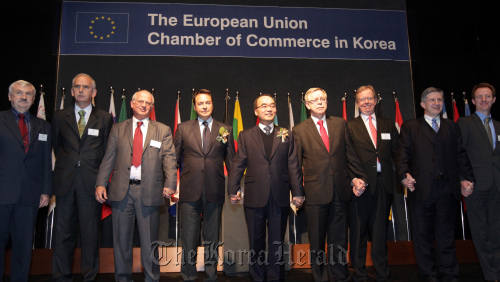 Korean Finance Minister Bahk Jae-wan (center) poses with Jean-Luc Valerio (fourth from left), president of the EU Chamber of Commerce in Korea, and Tomasz Kozlowski (fourth from right), ambassador and head of the EU delegation to Korea after delivering a speech at a luncheon meeting with the chamber members in Seoul on Monday.    Yonhap News