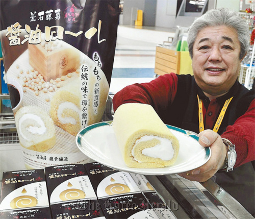 A clerk displays a Shoyu Roll cake at a shop in the city of Kamaishi, Iwate Prefecture, Japan.  Yomiuri Shimbun/MCT