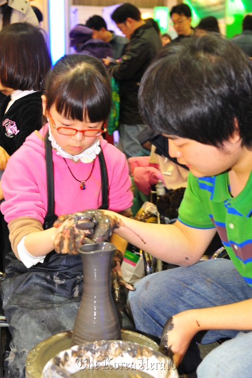 Children try their hand at pottery making during the 2011 Korea Travel Expo. The Korea Tourism Association