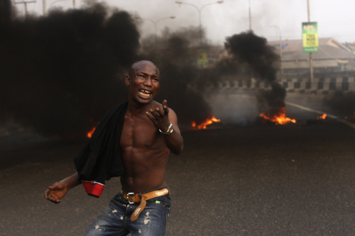 <YONHAP PHOTO-1418> A angry youth protest in front of a burning barrier following the removal of a fuel subsidy by the government in Lagos, Nigeria, Tuesday, Jan. 10, 201. Angry youths erected a burning roadblock outside luxury enclaves in Nigeria's commercial capital Tuesday as a paralyzing national strike over fuel prices and government corruption entered its second day.(AP Photo/Sunday Alamba)/2012-01-10 18:47:42/ <저작권자 ⓒ 1980-2012 ㈜연합뉴스. 무단 전재 재배포 금지.>
An angry youth protests in front of a burning barrier in Lagos, Nigeria on Tuesday. AP-Yonhap News