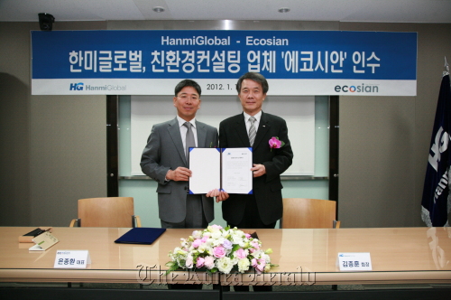 HanmiGlobal chairman Kim Jong-hoon (right) poses after signing an acquisition deal with Ecosian chief executive Eun Jong-hwan on Tuesday in Seoul. HanmiGlobal Co.
