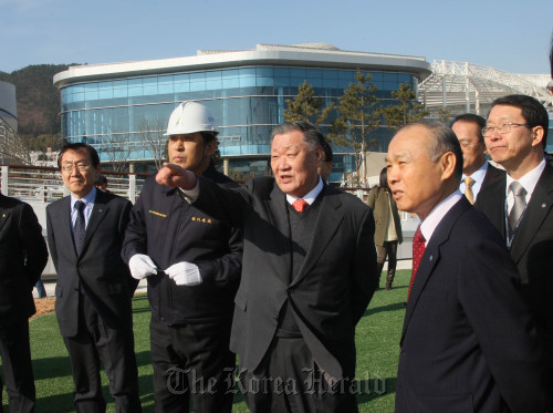 Hyundai Motor Group chairman Chung Mong-koo (center) gestures during his visit to the construction site of the 2012 Yeosu Exposition in South Jeolla Province, on Thursday.  Expo organizing committee chief Kang Dong-suk (right, front row) also attended the inspection.      Yonhap News