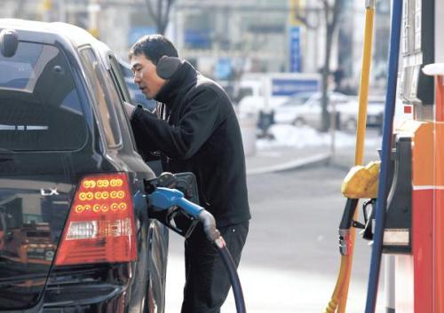 An attendant talks to a customer while filling the vehicle’s tank at a SK Energy Co. gas station in Seoul. (Bloomberg)