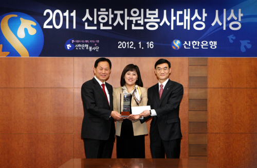 서진원(왼쪽) 신한은행장이 16일 서울 태평로 본점에서 열린 ‘2011 신한자원봉사대상 시상식’에서 영예의 대상을 수상한 신탁부 이도형 부장(오른쪽)ㆍ박혜영 차장과 기념촬영을 하고 있다.  [신한은행제공]