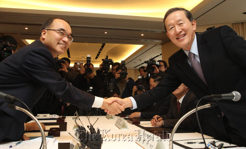 Finance Minister Bahk Jae-wan (left) shakes hands with FKI chairman Huh Chang-soo before starting a meeting with heads of major business lobby groups in Seoul on Thursday.    Yonhap News