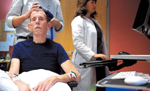 Frank McKinney, a patient at Cardinal Hill Rehabiliation Center, is evaluated by KC Chelette (left) and Dr. Lumy Sawaki (right), during therapy for a stroke in Lexington, Kentucky. (Lexington Herald-Leader/MCT)